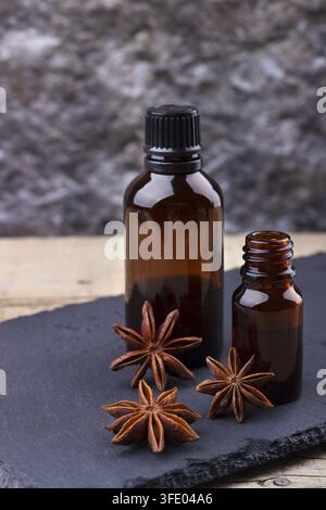 L'huile essentielle d'anis dans de petites bouteilles sur pierre noire mise au point sélectionné, Banque D'Images