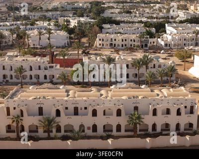 Vue élevée sur Charm el-Cheikh, Égypte, avec des bâtiments de resort blancs, des palmiers et les montagnes du Sinaï en arrière-plan. Banque D'Images