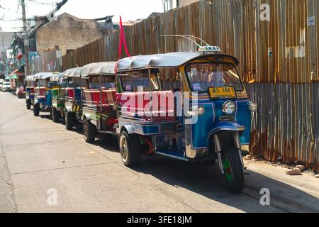 Tuk-Tuks colorés garés le long d'une ruelle urbaine de Bangkok Banque D'Images