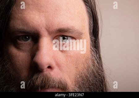 Close-up intense d'un homme barbu aux cheveux longs Banque D'Images
