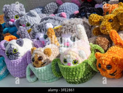 Vue rapprochée d'une collection vibrante de jouets en peluche amigurumi tricotés à la main exposés sur une table à un marché artisanal en plein air. Exposition artisanale f Banque D'Images