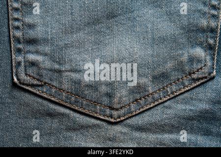 Close up de la poche arrière de jeans bleu classique avec surpiqûres brunes. Vue détaillée en cadre complet de la poche arrière en denim bleu texturé présentant une ora traditionnelle Banque D'Images