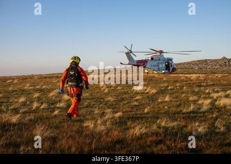 Le paramédic de sauvetage en montagne se dirige vers l’hélicoptère SAR de la Garde côtière britannique lors d’une opération sur Cadair Idris, Snowdonia Eryri, au Pays de Galles, Royaume-Uni. Banque D'Images