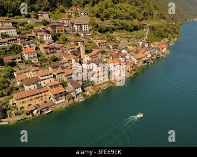 Vue aérienne du village de Gandria avec des maisons en pierre et des toits en terre cuite sur les rives du lac, Lugano, Tessin, Suisse. Banque D'Images