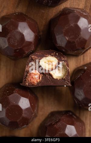 Truffes artisanales au chocolat avec des noix sur une surface en bois Banque D'Images