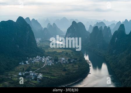 Vue aérienne du fleuve Li pittoresque serpentant entre des montagnes karstiques et des villages ruraux chinois Banque D'Images