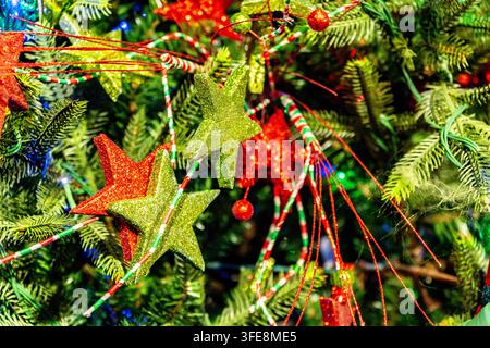 Étoiles vertes et rouges étincelantes sur un sapin de Noël Banque D'Images
