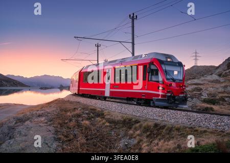 Train BERNINA Express près du lac Bianco en Suisse au coucher du soleil Banque D'Images