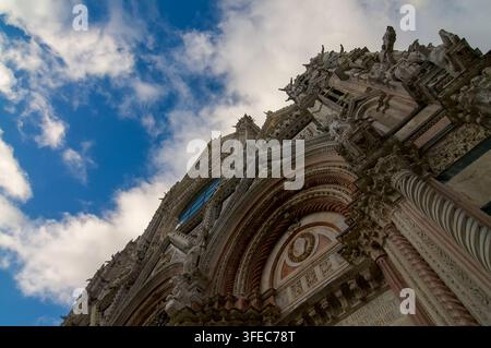 Sienne, Toscane, Italie - 8 octobre 2021 : vue en contre-plongée des arcs du portail sculptés, des colonnes en spirale et des sculptures de la cathédrale de Sienne (Duomo di Siena) Banque D'Images