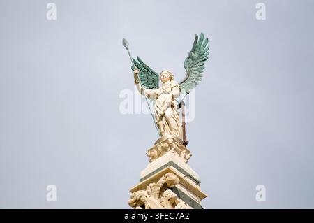 Sienne, Toscane, Italie - 8 octobre 2021 : Gros plan de la statue d'ange en bronze tenant une lance au sommet de la façade gothique du dôme de Sienne Banque D'Images