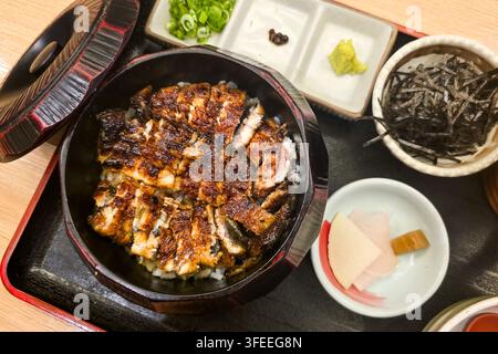 Gros plan d'une portion de délicieux set traditionnel unagi donburi teishoku dans un restaurant japonais. Composé de riz, d'unagi grillé avec sauce, de soupe, de cornichon Banque D'Images