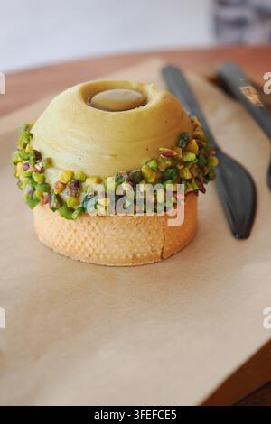 Cuillère à glace au pistache avec noix hachées sur un gâteau waffle Banque D'Images