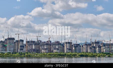 Grand chantier de construction d'appartements avec des grues-tours vu depuis le fleuve Han à Séoul, en Corée du Sud. Banque D'Images