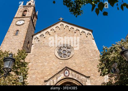 Barcelone, Espagne 31.08.2026 Façade historique en pierre remplit le cadre, associée à une haute tour d'horloge et à une façade d'église ornée. Fenêtre circulaire, moulure en arc et Banque D'Images