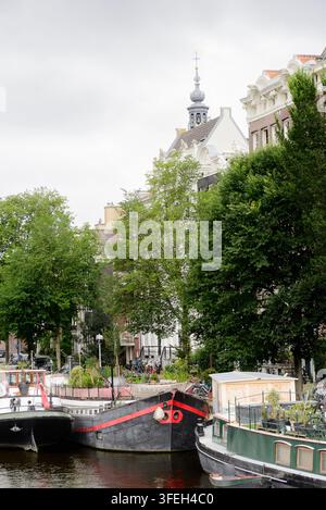 Péniches amarrées le long d'un canal classique d'Amsterdam Banque D'Images