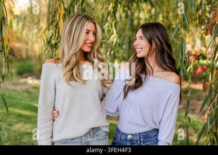 Deux jeunes femmes se souriant sous un arbre Banque D'Images