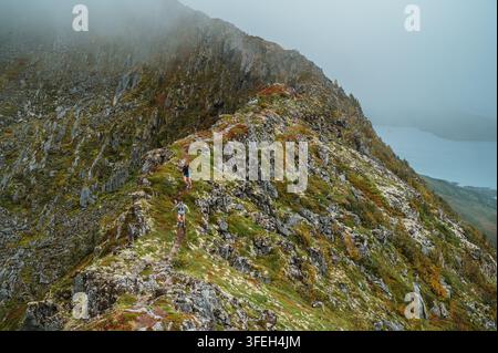 Athlètes courant le long d'une crête de haute montagne Banque D'Images