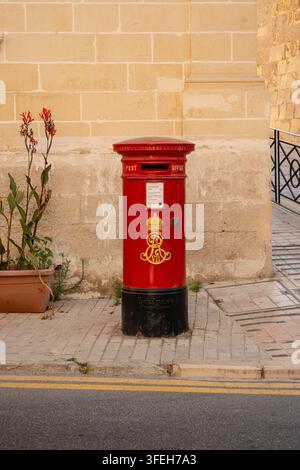 Boîte aux lettres rouge vintage sur une rue ensoleillée Banque D'Images