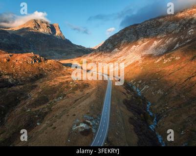 Vue aérienne de la route sinueuse dans la haute vallée alpine au coucher du soleil Banque D'Images