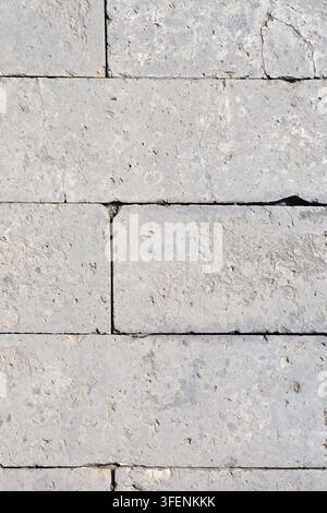 Texture murale en calcaire gris naturel avec fond à motifs de blocs de maçonnerie érodés Banque D'Images