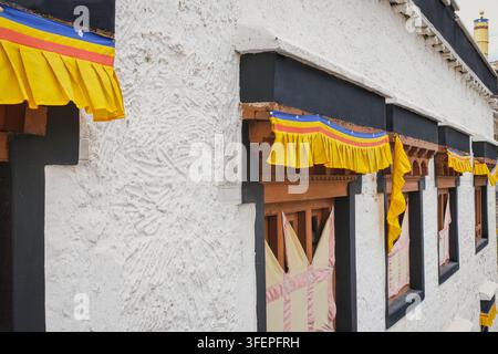 Fenêtres traditionnelles, décoration textile colorée sur un mur blanchis à la chaux au monastère de Ladakh, Inde, architecture bouddhiste himalayenne. Banque D'Images