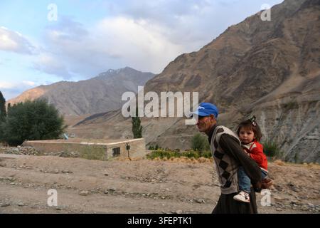District de Ghizer, Pakistan. 04 sep, 2026. Un homme porte un enfant sur son dos le long d'une route dans le district de Ghizer, Gilgit-Baltistan, Pakistan, le 4 septembre 2026. Le département du tourisme de Gilgit-Baltistan compte le col de Shandur, la vallée de Hundarap et la vallée de Langar parmi les destinations touristiques et les zones de loisirs du district de Ghizer. (Photo de Zubair Abbasi/Middle East Images/StringersHub/Sipa USA) Crédit : Sipa USA/Alamy Live News Banque D'Images