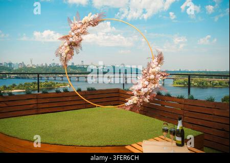 Vue panoramique depuis un toit avec une arche de cérémonie de mariage décorée d'arrangements floraux roses délicats en plein air. Banque D'Images