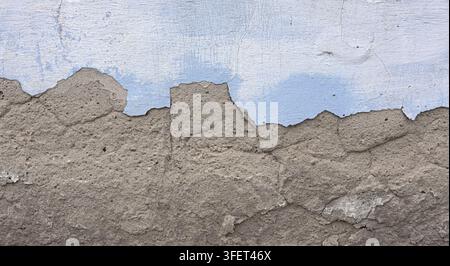 Mur érodé avec de la peinture qui s'écaille, révélant une surface bleue et grise délabrée Banque D'Images