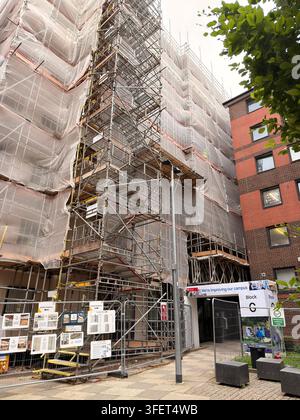 Bâtiment de campus à plusieurs étages recouvert d'échafaudages, les travaux de rénovation améliorent les installations aujourd'hui. Banque D'Images