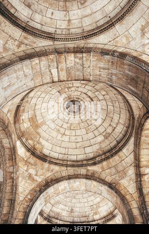 Vue par le bas de la voûte en dôme de pierre de la basilique monumentale du Sacré-Cœur de Montmartre, avec des arches de brique détaillées et des structures en pierre concentriques Banque D'Images