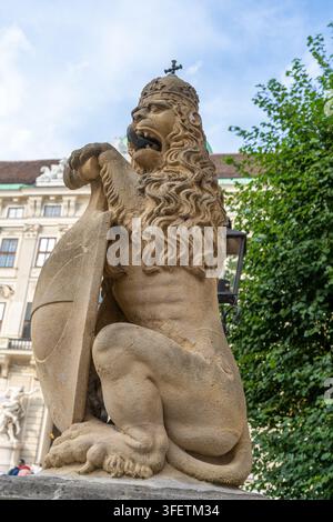 Statue d'un lion couronné de pierre avec bouclier près du bâtiment du palais impérial de la Hofburg dans la vieille ville de Vienne, Autriche. Banque D'Images