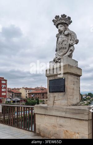 Statue d'un lion couronné tenant un blason sur le pont Carlos III à Miranda de Ebro, Burgos, Espagne, sous un ciel nuageux. Banque D'Images