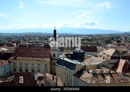 Vue panoramique de la tour du conseil de Sibiu et de la Grande Place avec les montagnes Făgăraş en arrière-plan, Sibiu, Transylvanie, Roumanie. Banque D'Images