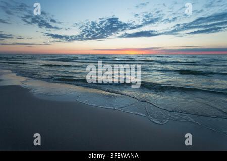 Vagues calmes de la mer Baltique et plage au coucher du soleil, vue estivale Banque D'Images