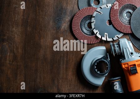 Meuleuse électrique avec une gamme de disques de coupe, diamantés et à lamelles sur fond en bois sombre, gros plan. Parfait pour les quincailleries Banque D'Images