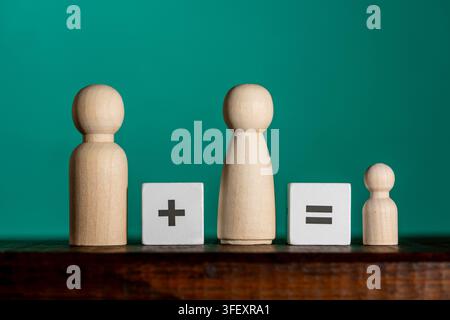Concept de planification familiale avec des figurines en bois et des signes mathématiques. Poupées en bois et puzzle de symboles mathématiques représentant la croissance traditionnelle de la famille ne Banque D'Images
