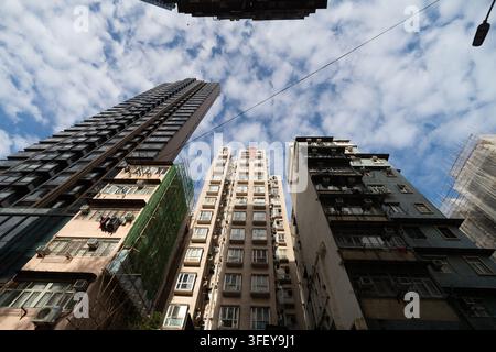 Mettant en lumière la vie urbaine dense, une vue en contre-plongée capture des immeubles d'habitation imposants à Sham Shui Po, Kowloon, Hong Kong. Banque D'Images