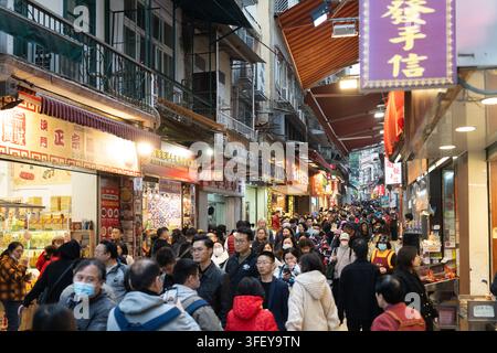 Les touristes encombrent la rue étroite menant aux ruines de Saint-Paul à Macao pour acheter des souvenirs locaux et visiter les sites touristiques. Banque D'Images