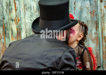 SAN MIGUEL DE ALLENDE, MEXIQUE – 02 NOVEMBRE 2019 : Un homme chapeau haut de forme et un enfant au visage peint partagent un moment tendre. La scène semble faire partie de Banque D'Images