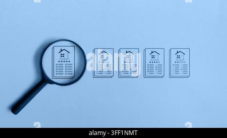 Une loupe se concentre sur un document de propriété hautement coté parmi d'autres, symbolisant la sélection immobilière et l'évaluation du logement. Concept d'Apprais Banque D'Images