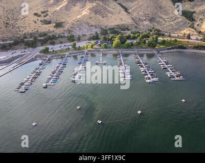 Vue aérienne du port de plaisance de Lucky Peak près de Boise, Idaho, avec des bateaux amarrés dans des eaux calmes. Des collines et des arbres bordent le rivage derrière le quai. Petite bu Banque D'Images