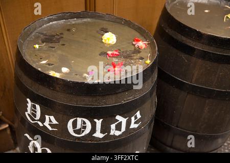 Des pétales de fleurs décoratifs flottent dans des tonneaux remplis d'eau à l'extérieur du pub historique Ye Olde Mitre à Ely Court, Holborn, Londres. Banque D'Images