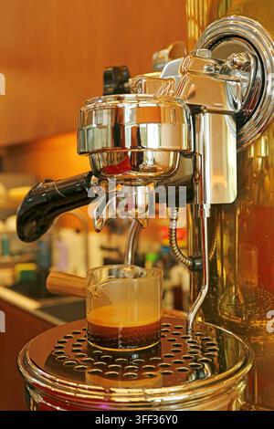 Un shot d'expresso frais versé d'une machine à levier professionnelle dans un verre Banque D'Images