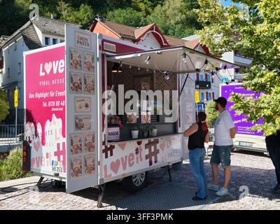 Bad Herrenalb, Allemagne, 5 septembre 2026 Camion ambulant de crêpes dessert avec fenêtre de service ouverte, lumières suspendues, panneaux de menu et clients commandant Banque D'Images
