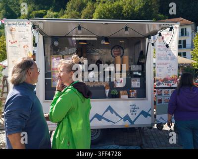 Bad Herrenalb, Allemagne, 5 septembre 2026 : Marché de rue en plein air sur une place historique ensoleillée avec des food-trucks, des tables d’extérieur ombragées, des clients, pavé Banque D'Images