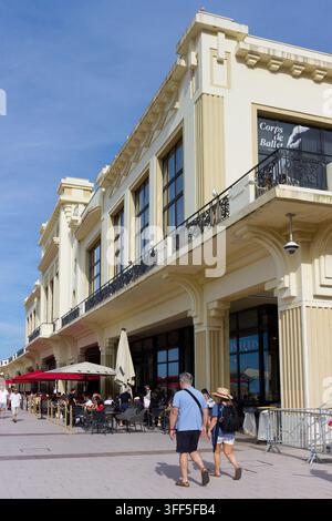 Les visiteurs déambulent dans la rue de Biarritz, profitant des cafés et des boutiques au soleil. Banque D'Images
