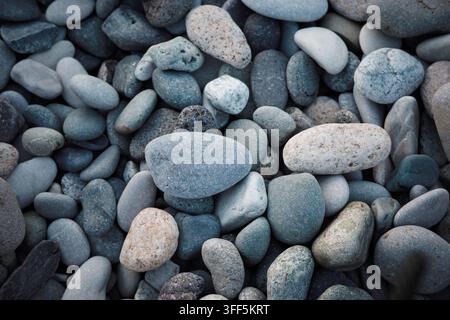 Fond de galets de mer, texture de pierres côtières lisses en tons gris, motif naturel pour plage, spa, bien-être, géologie, fond de conception minimaliste. Banque D'Images