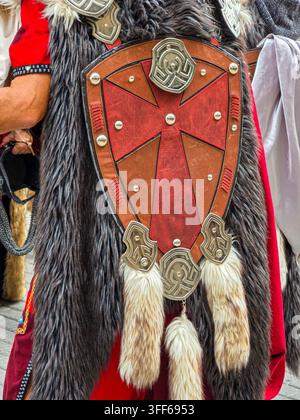 Cette scène présente une pièce d'armure fantastique avec une bordure en fourrure gris foncé sur une cape rouge. L'armure possède un bouclier central en cuir brun et rouge Banque D'Images