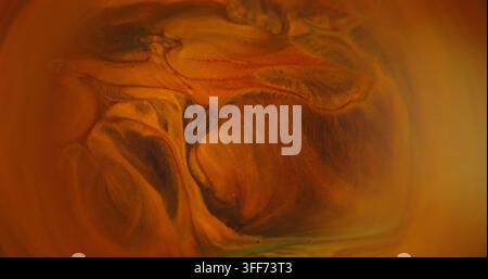Vague de paillettes floues. Éclaboussure de peinture orange. Texture étincelante de pigment jaune chaud, eau brillante et fluide sur fond abstrait. Banque D'Images