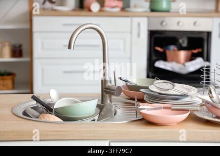 Ménages et vie domestique, pile de vaisselle sale dans l'évier de la cuisine avec un plan de travail désordonné et des assiettes non lavées après une soirée à la maison Banque D'Images